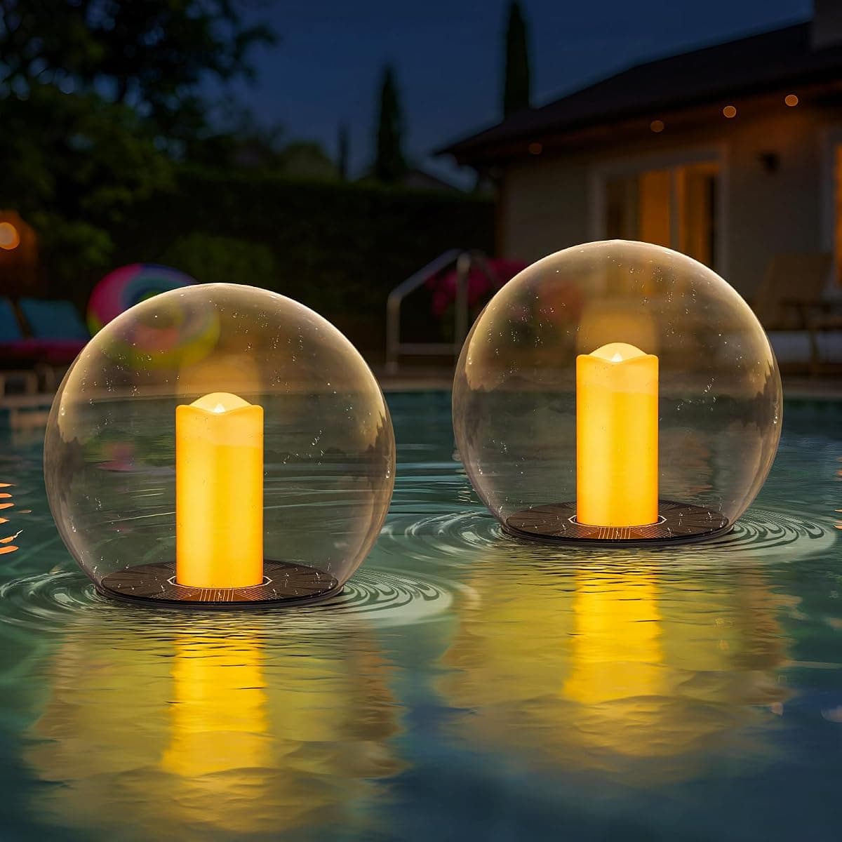 Two glass globes each holding a flickering candle, floating on a dark pool