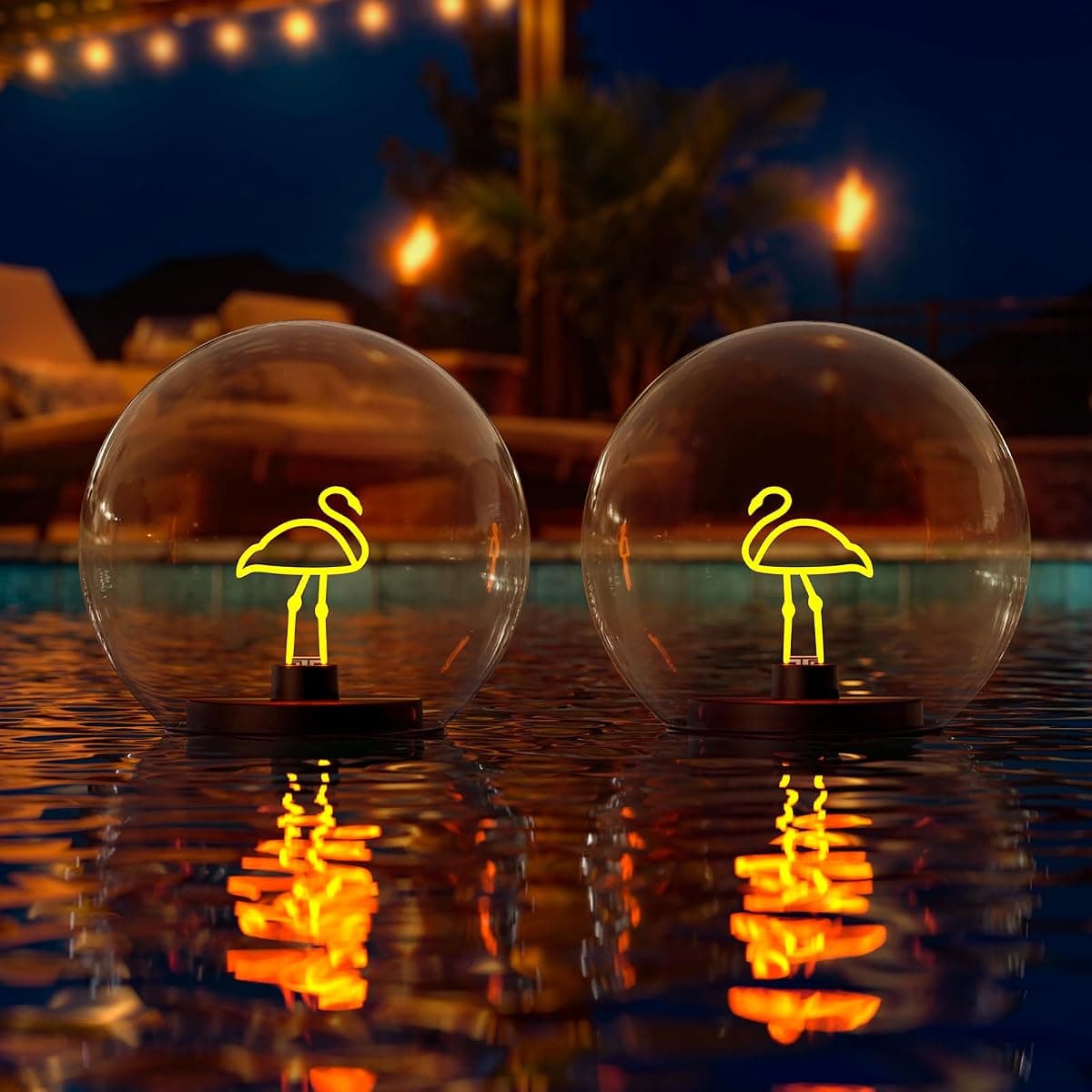 Two floating globes holding neon flamingo filaments, reflected in dark water